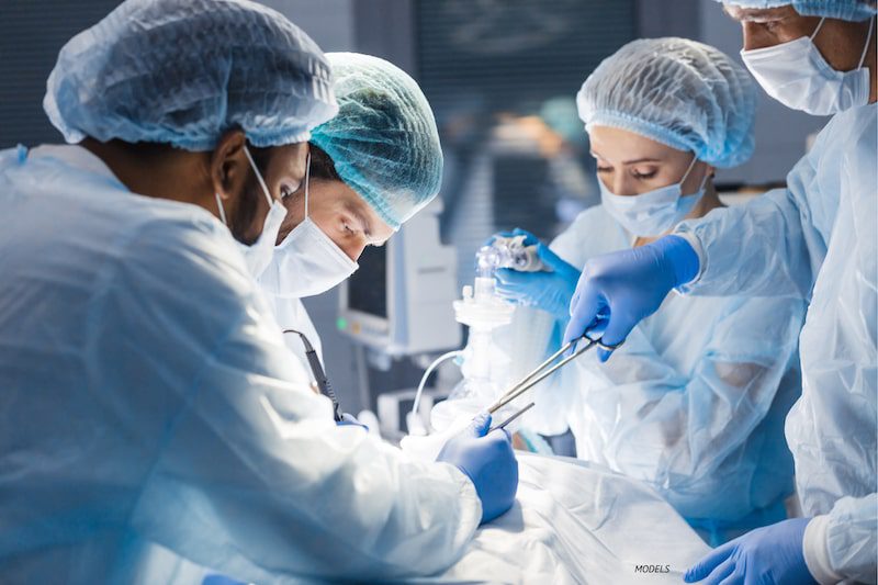 Surgeons operating on a patient in an operating room.