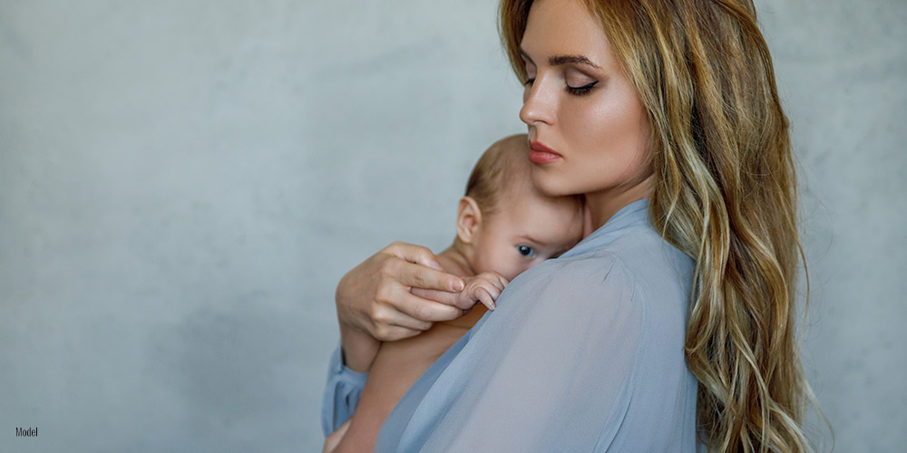 Mom holding her chid in studio background